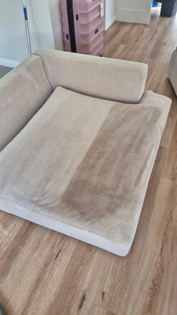 Upholstery cleaning - fabric cushion half cleaned showing the soiling removed