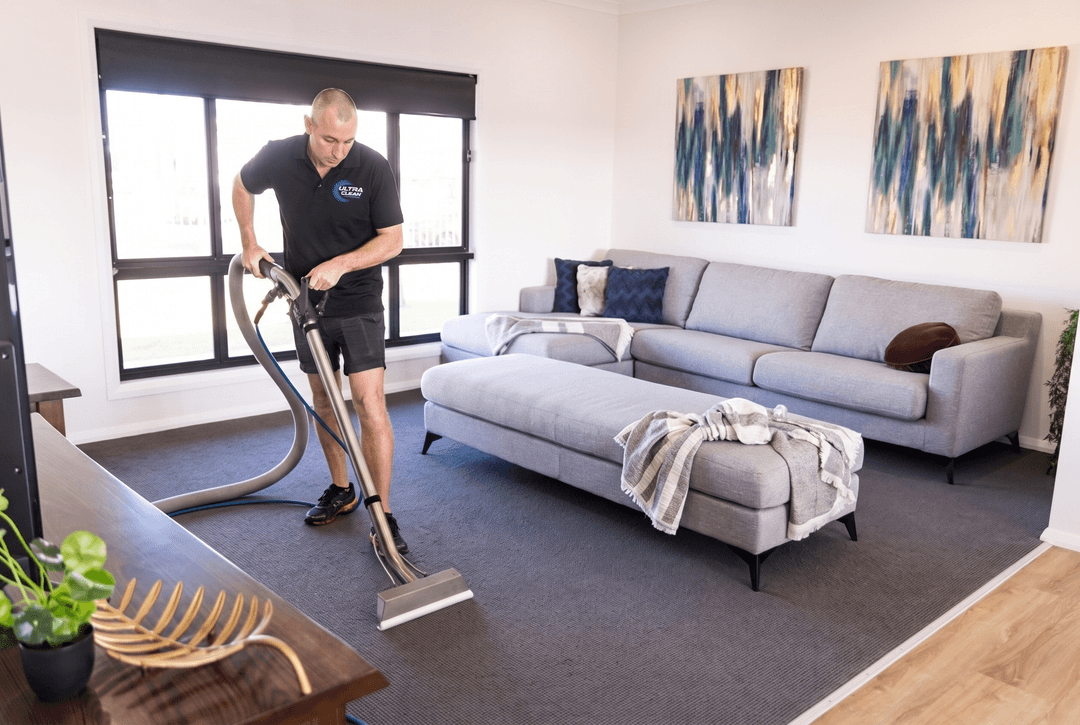 Lee from Ultraclean Swan Hill steam cleaning a lounge carpet